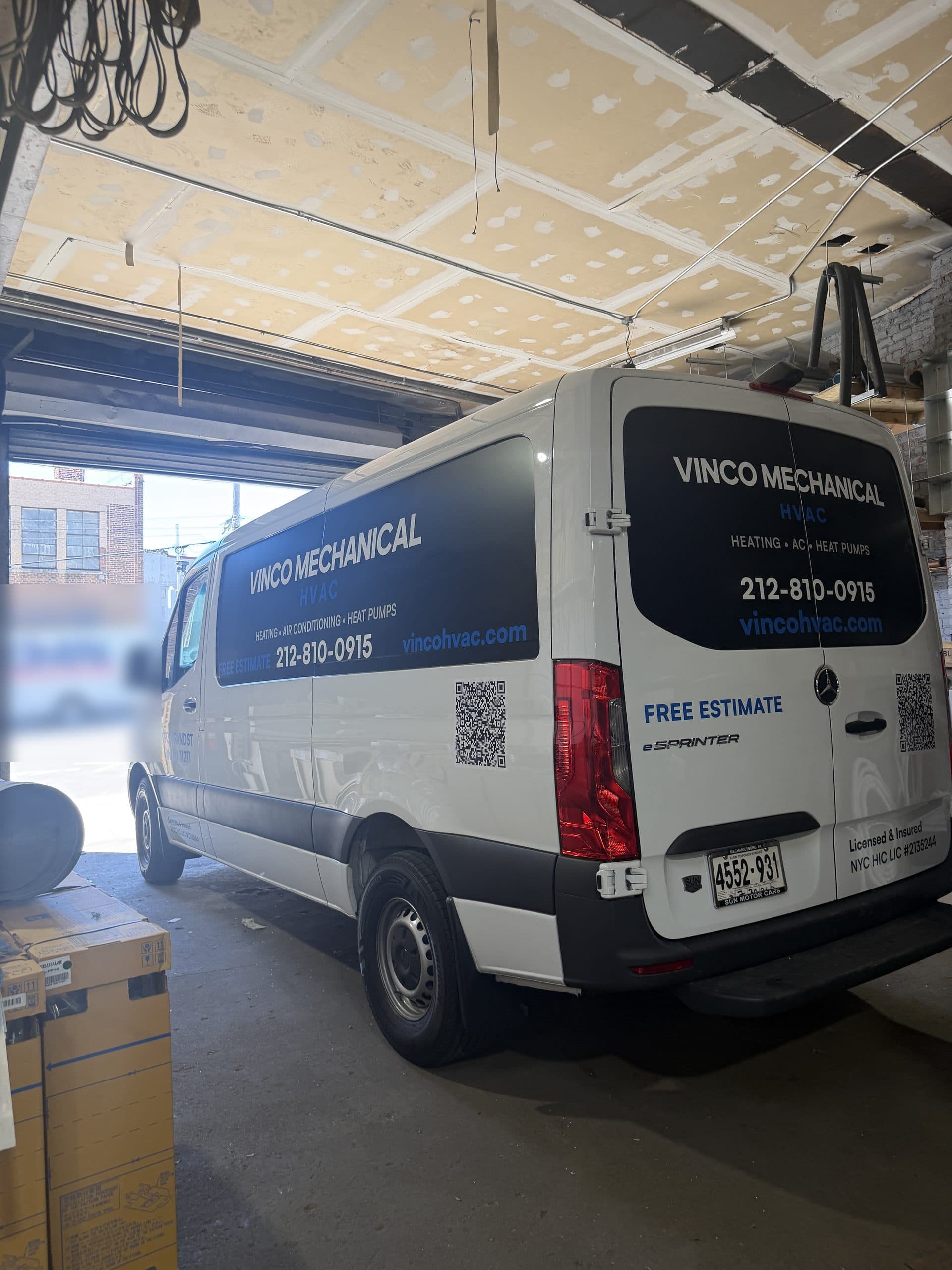 White Mercedes eSprinter electric van in Vinco Mechanical free-estimate livery parked in the 993 Grand Street shop doorway
