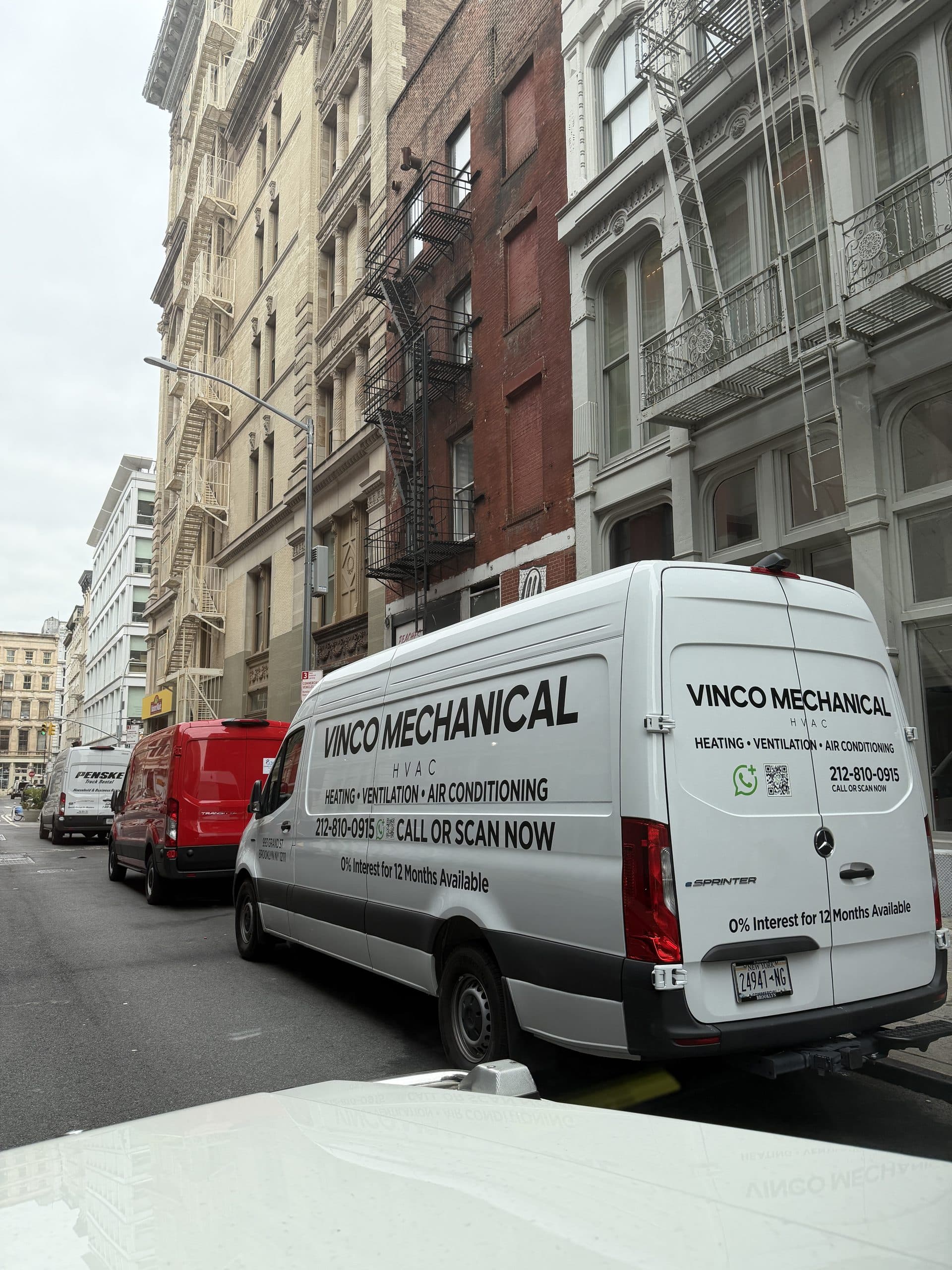 White Mercedes eSprinter electric van in Vinco Mechanical livery parked on a SoHo cast-iron street, eSprinter badge and Brooklyn commercial plate visible