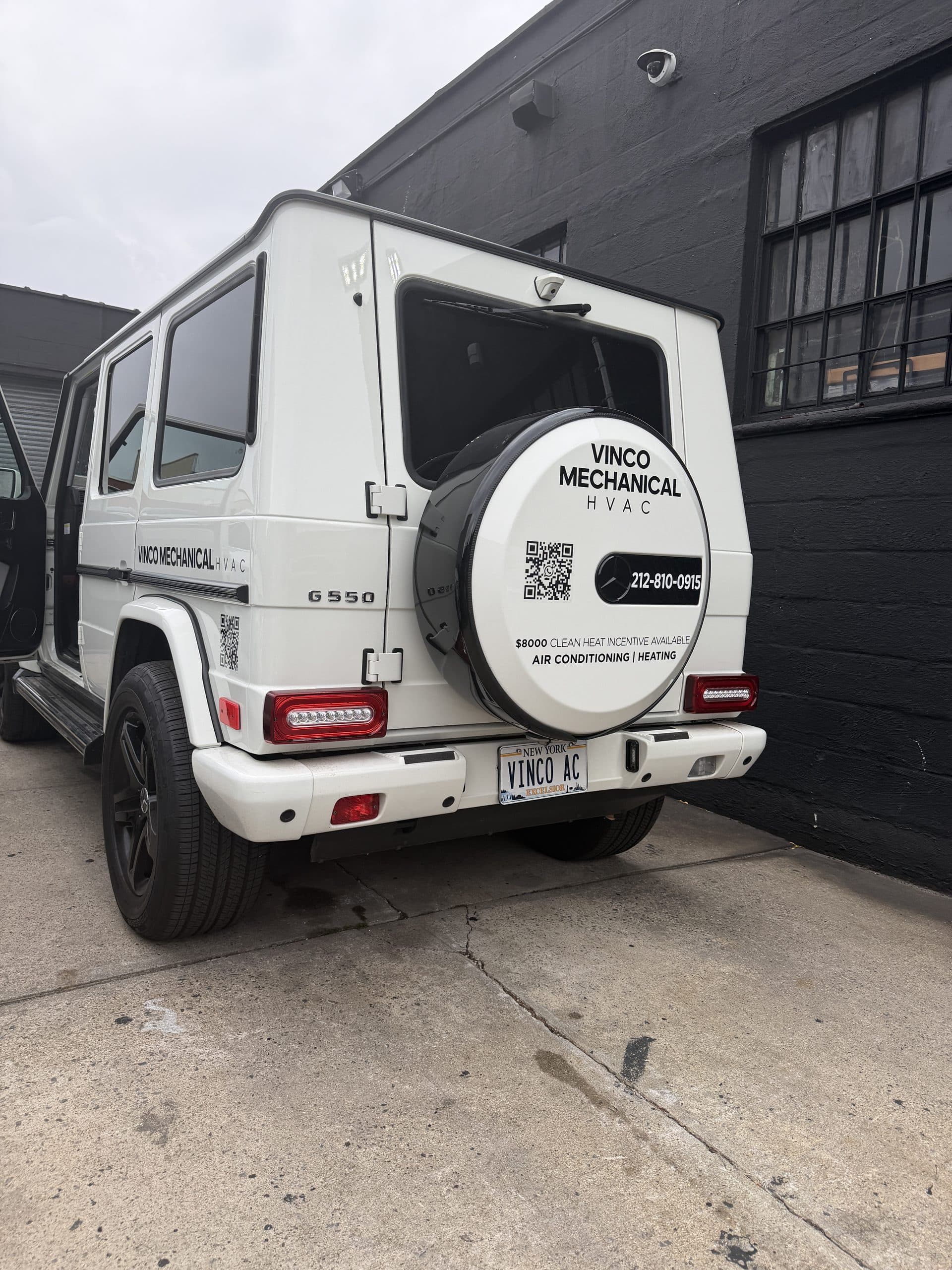Vinco Mechanical G-Wagon rear with a branded spare-tire cover reading the $8,000 Clean Heat incentive and the 212-810-0915 line