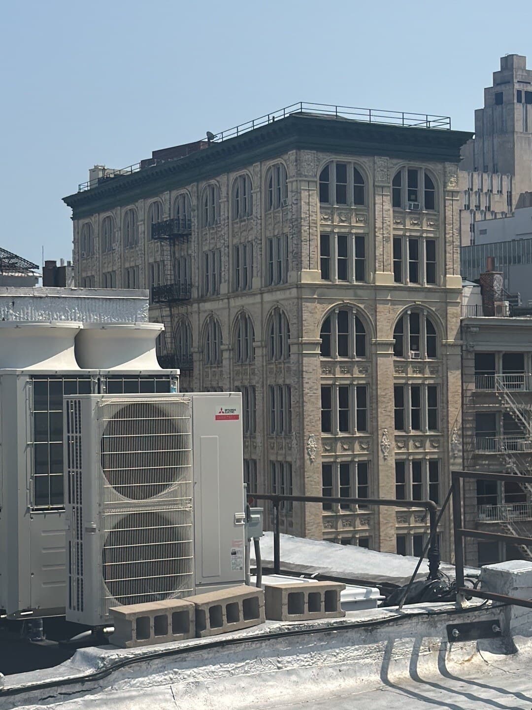 Mitsubishi Electric VRF outdoor condenser on a SoHo rooftop with an ornate cast-iron building behind