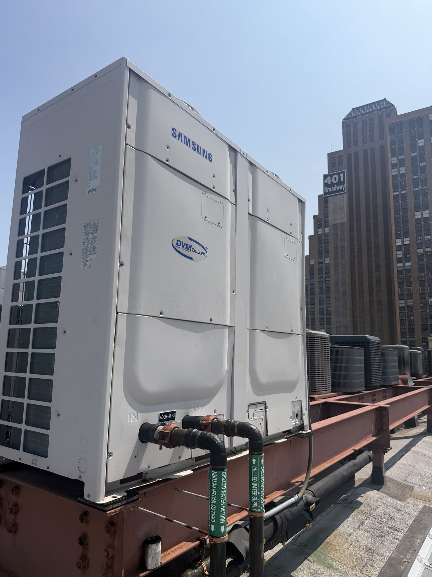 Samsung DVM air-cooled modular chiller on a Lower Manhattan commercial rooftop with chilled-water supply and return piping tied in