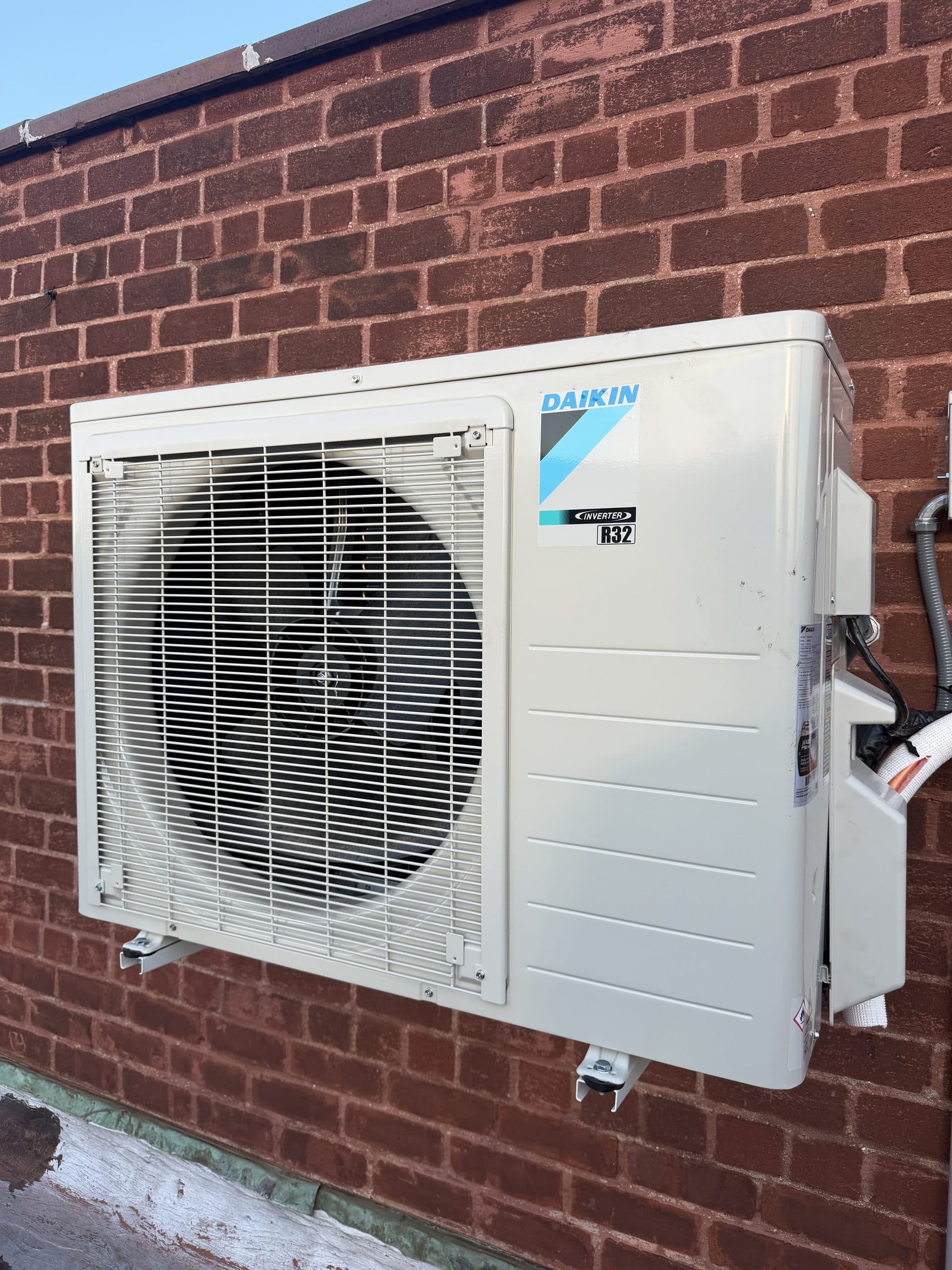 Daikin wall-mounted inverter condenser installed on a brick wall