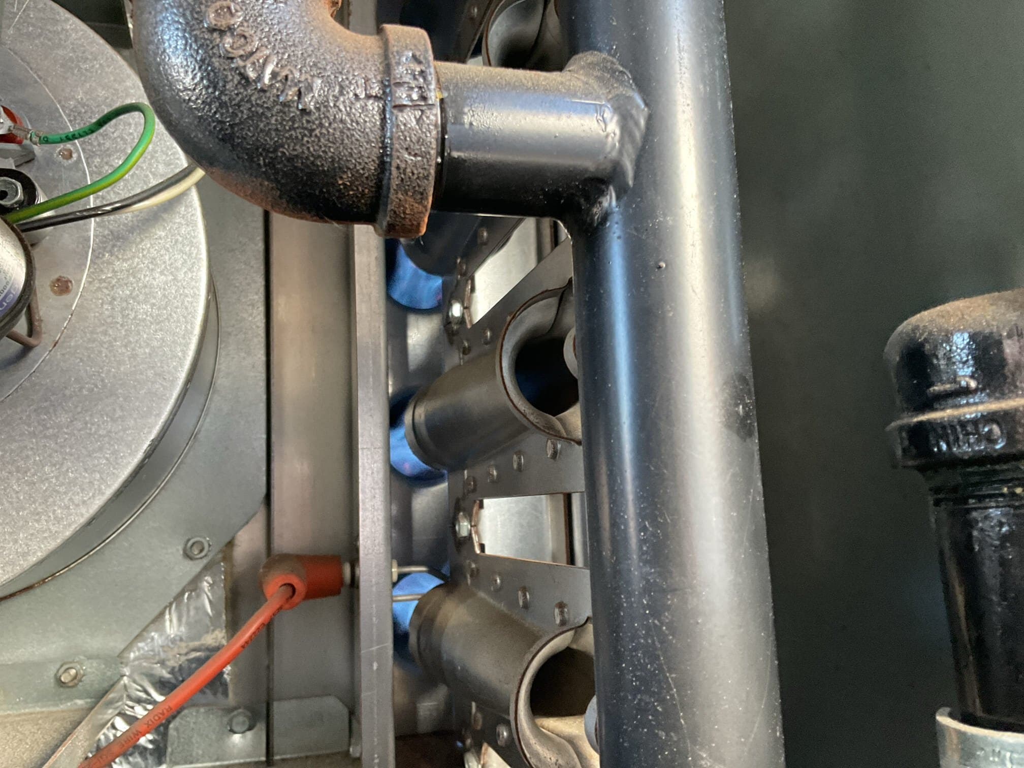 Gas furnace burner section firing with blue flames during a maintenance inspection at a Red Hook community facility